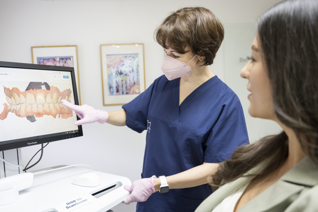 Mitarbeiterin der Praxis Dres. Laubinger erklärt einer Patientin ein digitales Zahnmodell am Bildschirm.